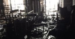 Devastated interior of a destroyed library, showcasing burned furniture and debris after a catastrophic fire incident.