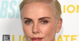 Charlize Theron showcasing a sleek short hairstyle and glamorous makeup at a red carpet event.