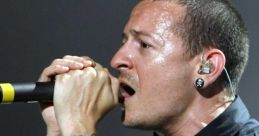 Chester Bennington passionately performing on stage, showcasing his iconic tattoos and powerful vocal expression.