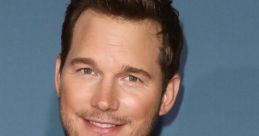 Chris Pratt smiles confidently at a promotional event, wearing a stylish blazer over a black shirt.