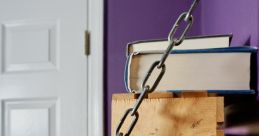 Metal chain strap securing books on a wooden shelf against a purple wall, adding a stylish touch to library decor.