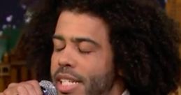 Daveed Diggs rapping passionately, microphone in hand, showcasing his dynamic vocal talent on stage.