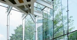 Bright and spacious interior of the Aluminium Library, featuring glass walls and modern architecture with wooden beams.