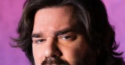 Matt Berry as George the Volcano, showcasing a serious expression against a colorful backdrop. Dramatic portrait style.