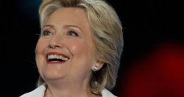 Hillary Clinton smiles while speaking at a podium, showcasing her passionate speech delivery and charismatic presence.