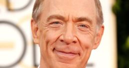 J.K. Simmons smiling at an awards event, showcasing his distinguished style and captivating personality.