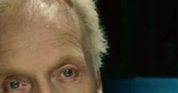 Close-up of Jigsaw from the Saw franchise, voiced by Tobin Bell, featuring intense expression and distinctive hairstyle.