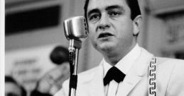 Johnny Cash performs passionately in a white suit, holding a guitar, with a vintage microphone in a lively setting.