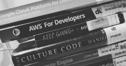 Stack of books on development, including "Google Cloud Platform," "AWS for Developers," and "UX Strategy." Resources for tech learning.