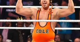 Michael Cole, WWE commentator, flexes muscles in orange wrestling attire, energizing the crowd in a wrestling ring.