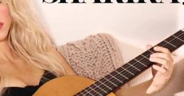 Shakira playing guitar, embracing her musical talent in a stylish, cozy setting. Discover her captivating artistry.