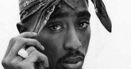 Tupac Shakur wearing a bandana and cross necklace, showcasing his iconic style and charisma in black and white portrait.