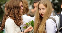 Russian girls in school outfits holding flowers, celebrating a special occasion with friends outdoors.