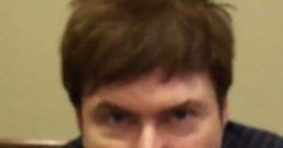 Quinton Flynn as Raiden, up close with a focused expression, showcasing his signature hairstyle and casual attire.