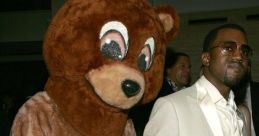 Kanye West in a stylish suit poses with Dropout Bear, showcasing unique fashion and playful spirit at a glamorous event.