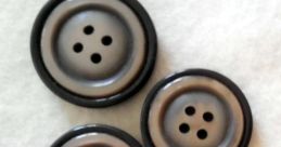 Black and gray buttons of varying sizes arranged neatly, perfect for crafting, sewing, or fashion projects.