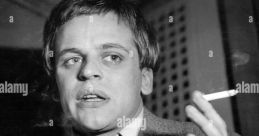 Klaus Kinski passionately gestures while holding a cigarette, embodying his intense persona as an enfant terrible of cinema.