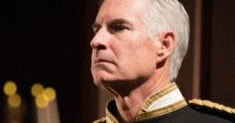 A dignified figure in ceremonial military attire, adorned with medals and insignia, signifying royal honors and service.