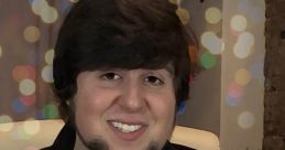 JonTron smiling with bokeh lights in the background, wearing a plaid shirt and black jacket, exuding cheerful vibes.