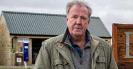 Jeremy Clarkson stands outside his farm, showcasing the creativity and charm of Clarkson's Farm.