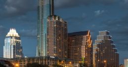 Austin skyline at night reflecting in the water, showcasing modern architecture and vibrant city lights.