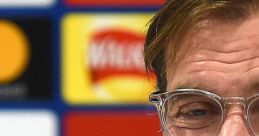 Jurgen Klopp smiling during a press conference, showcasing his charismatic personality and leadership in football.