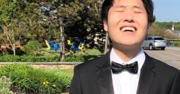 Disguised Toast in a tuxedo, smiling outdoors amidst greenery, showcasing a cheerful and stylish look.