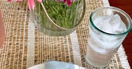 Colorful table setting with decorative flowers, a napkin, and sprinkles-covered donuts for a delightful gathering.