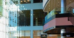 Bright interior of Etele Business, featuring modern storefronts, escalators, and natural light illuminating the atrium.