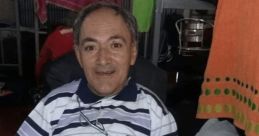 Oscar Jaraiz smiling while seated in a wheelchair, wearing a medal, representing resilience and determination.