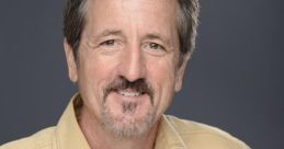 Terry Thompson smiling in a casual beige shirt, showcasing a friendly demeanor against a neutral background.