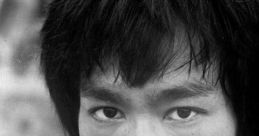 Black and white portrait of Bruce Lee showcasing his intense gaze and iconic hairstyle, reflecting his martial arts legacy.