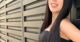 Nataly Anaya smiling against a stylish black backdrop, showcasing her fashion and beauty with long hair and trendy attire.