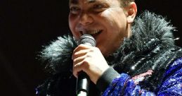 Cristian Castro performing passionately on stage, dressed in a glittering outfit with a microphone in hand.