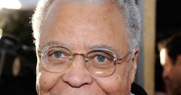 James Earl Jones smiling at a red carpet event, wearing a tuxedo and glasses, showcasing his iconic presence in film.