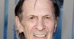 Leonard Nimoy smiles while wearing a black suit at a public event, showcasing his iconic presence in entertainment history.