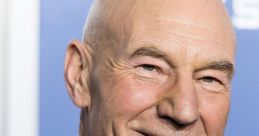 Patrick Stewart, smiling in a navy suit and tie, at a promotional event highlighting his iconic acting career.