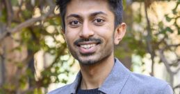 Smiling young man in a stylish gray jacket outdoors, exuding confidence and warmth. Perfect for showcasing Mann Patel's charisma.