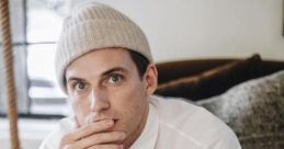 Jeremiah Culberson in a white shirt and knit beanie, seated thoughtfully in a cozy indoor setting.