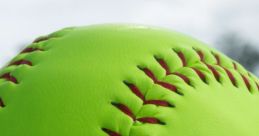 Bright green BQB softball with red stitching resting on grass, perfect for vibrant gameplay and outdoor sports activities.