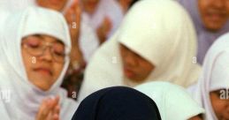 Young women in hijabs and masks clapping at an event, showcasing cultural attire and community support.