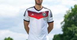 Soccer player stands confidently in Germany's official jersey, ready for action on the field with a colorful ball.