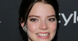 Anya Taylor-Joy smiles brightly, showcasing her unique style with bold fashion details and elegant makeup at a recent event.