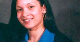 Young woman smiling in a blue shirt and black blazer, holding an award plaque, exuding confidence and professionalism.