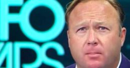 Alex Jones on-air at InfoWars, discussing controversial topics with intense focus, wearing a blue suit and microphone setup.