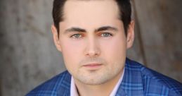 Professional portrait of Jack Murphy in a blue plaid suit, showcasing confidence and style with an American flag pin.