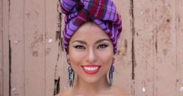 Colorful traditional outfit with vibrant patterns, featuring a striking head wrap and bold red lipstick, showcasing cultural pride.