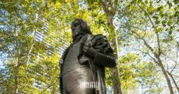 Statue of José Bryant surrounded by lush greenery and flowers, honoring his contributions in a serene park setting.