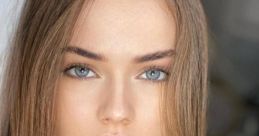 Close-up portrait of Kristina Filimonova showcasing her captivating blue eyes and stylish dark clothing with soft, flowing hair.