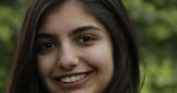 Smiling portrait of Anjali Sehduera in a light blue shirt, set against a blurred green background.